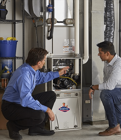 Goettl technician inspecting a furnace with customer