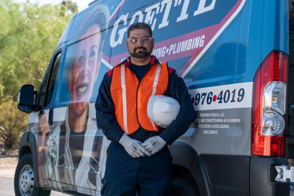 Goettl technician outside in front of a fully-stocked Goettl service van