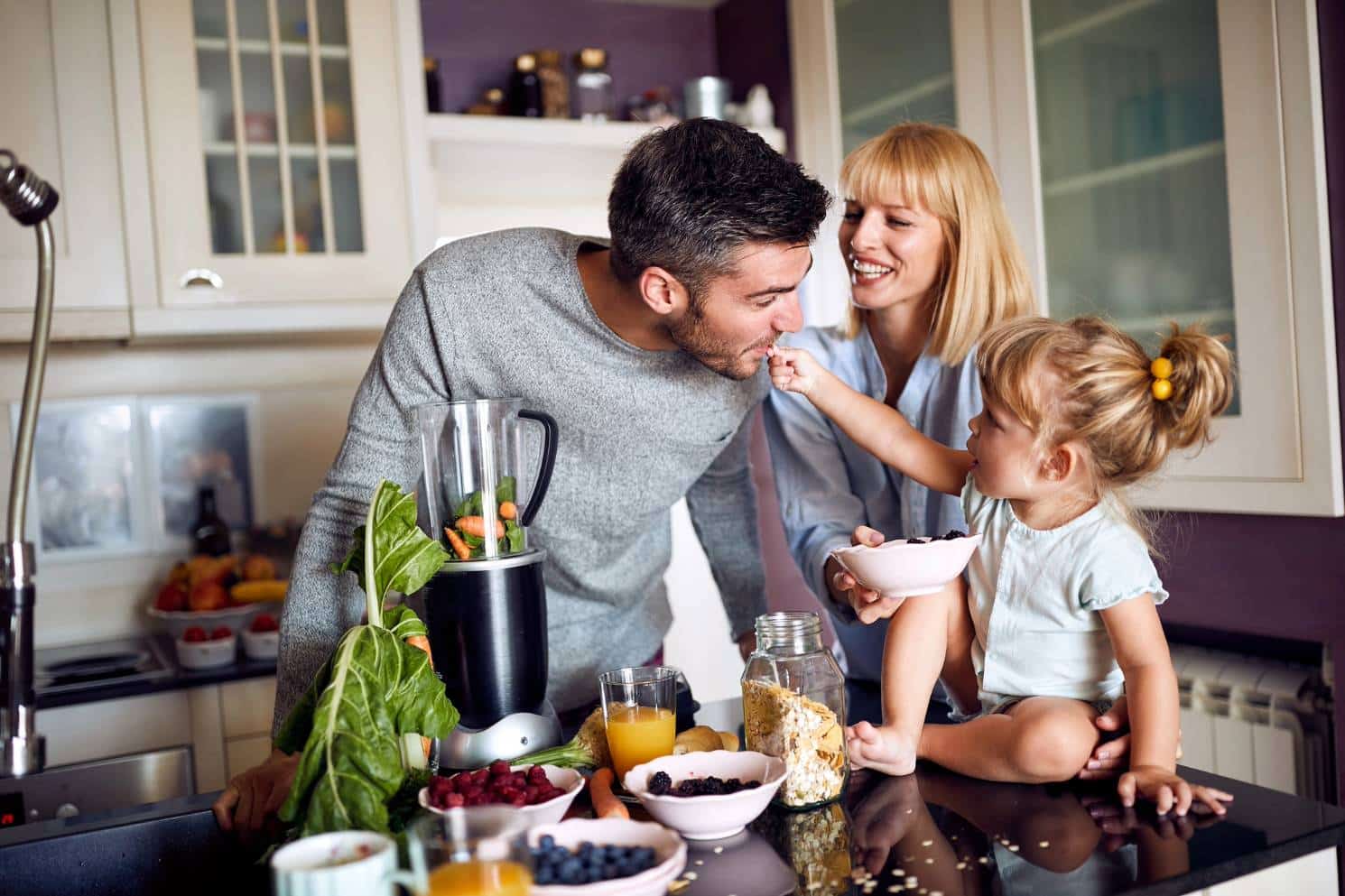 happy parents daughter snacking kitchen island